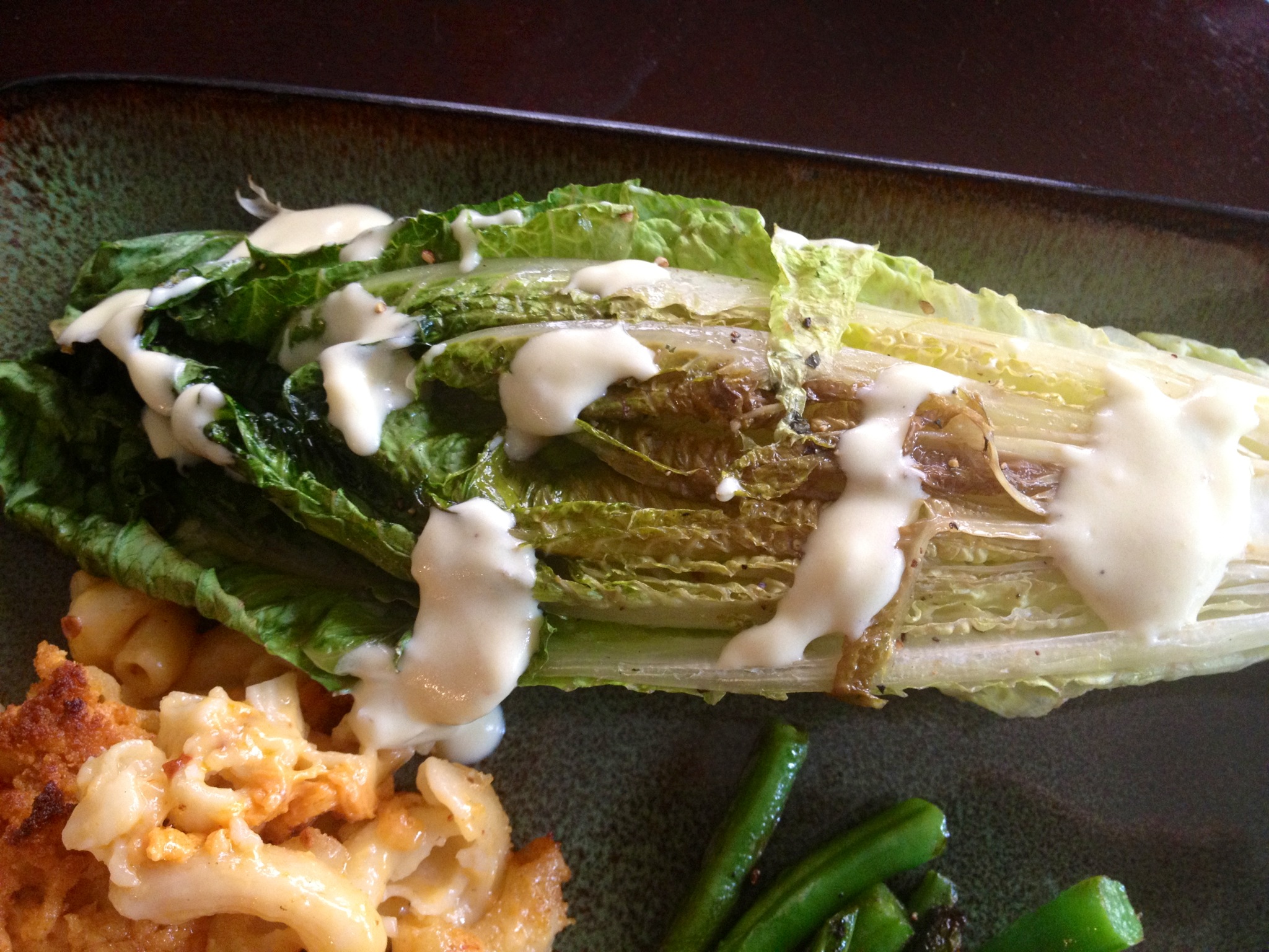 Grilled romaine lettuce drizzled with Caesar dressing