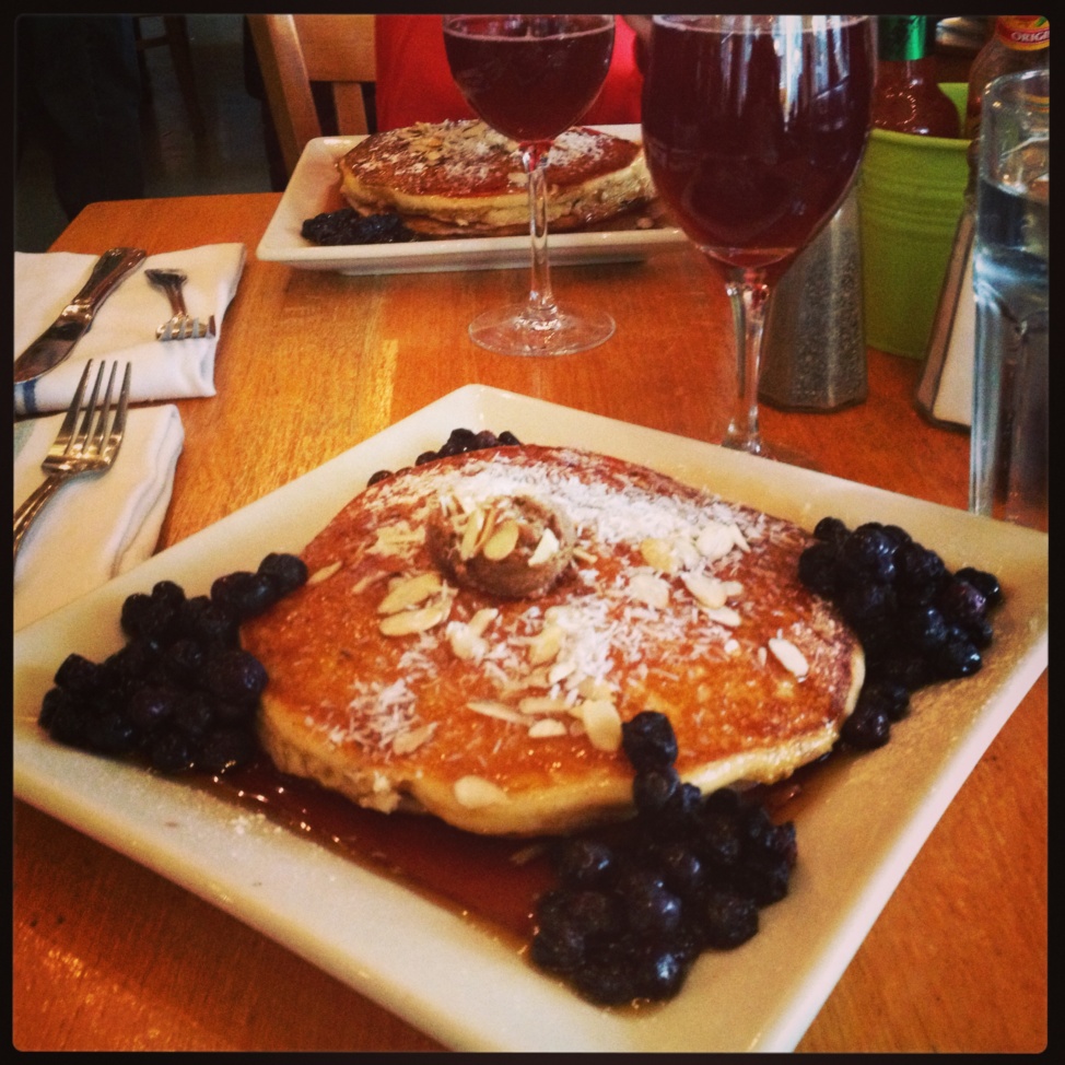 A square plate with pancakes and blackcurrants