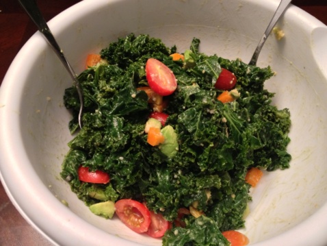 Kale and vegetable salad with Miso dressing in a grey bowl