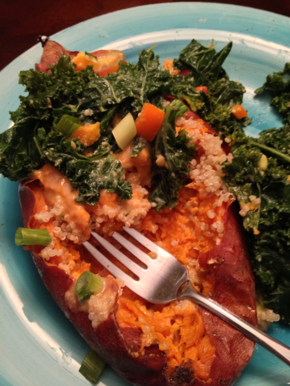 Awesomeness awaits you. A close up of a baked sweet potato with quinoa and kale
