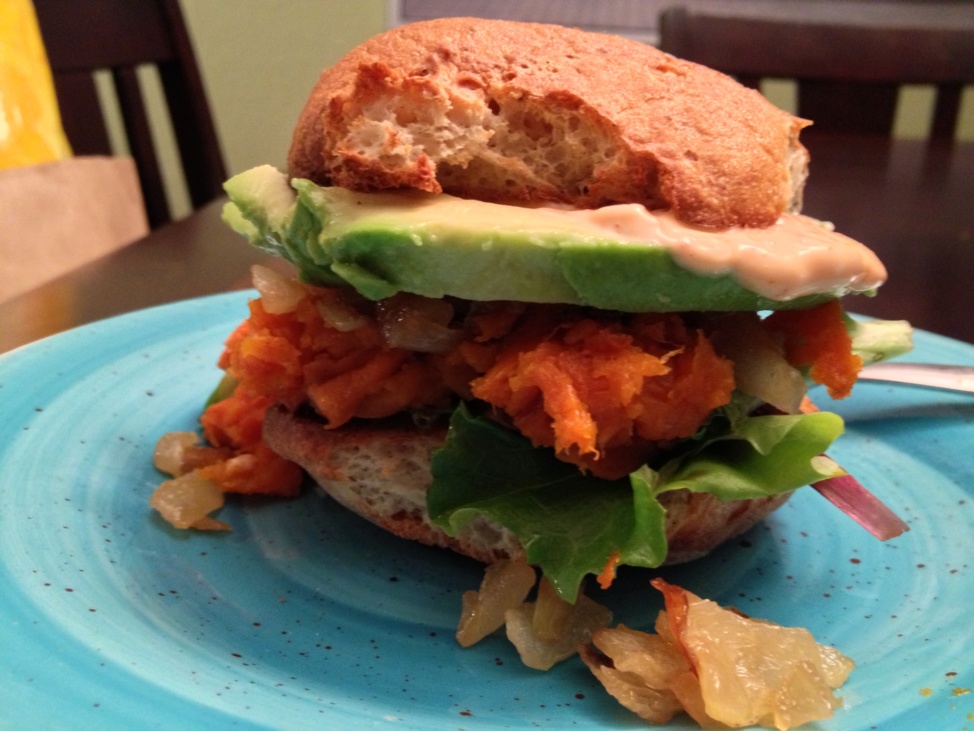 A sandwich with roasted sweet potato, caramelized onions and sriracha mayo