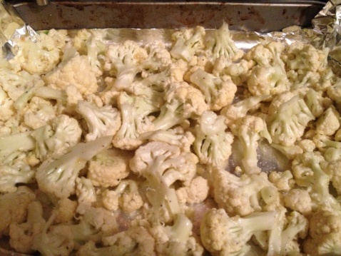 Raw cauliflower florets on a baking sheet