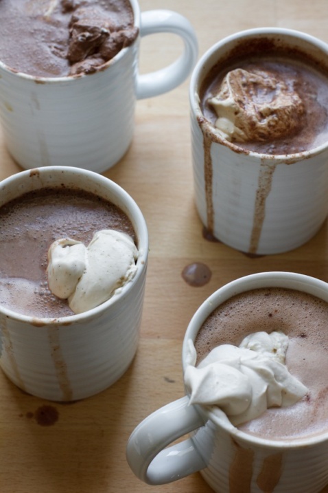 Four mugs with hot cocoa and whipped cream