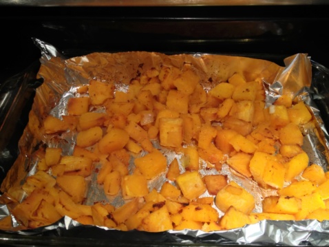 Roasted squash cubes on a baking sheet