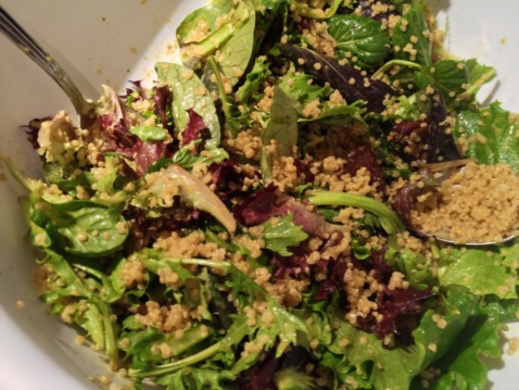 Greens and cooked quinoa in a white bowl