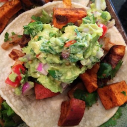 A Tortilla with roasted sweet potatoes and guacamole on it