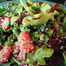 A green salad with quinoa, avocado, and strawberries