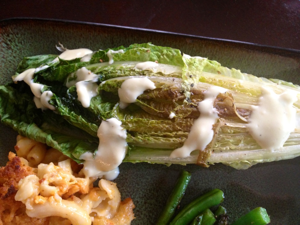 Grilled romaine lettuce drizzled with Caesar dressing
