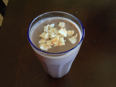 A purple protein hemp milkshake with coconut flakes on top