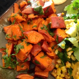 Roasted chopped sweet potatoes and a salad on a plate