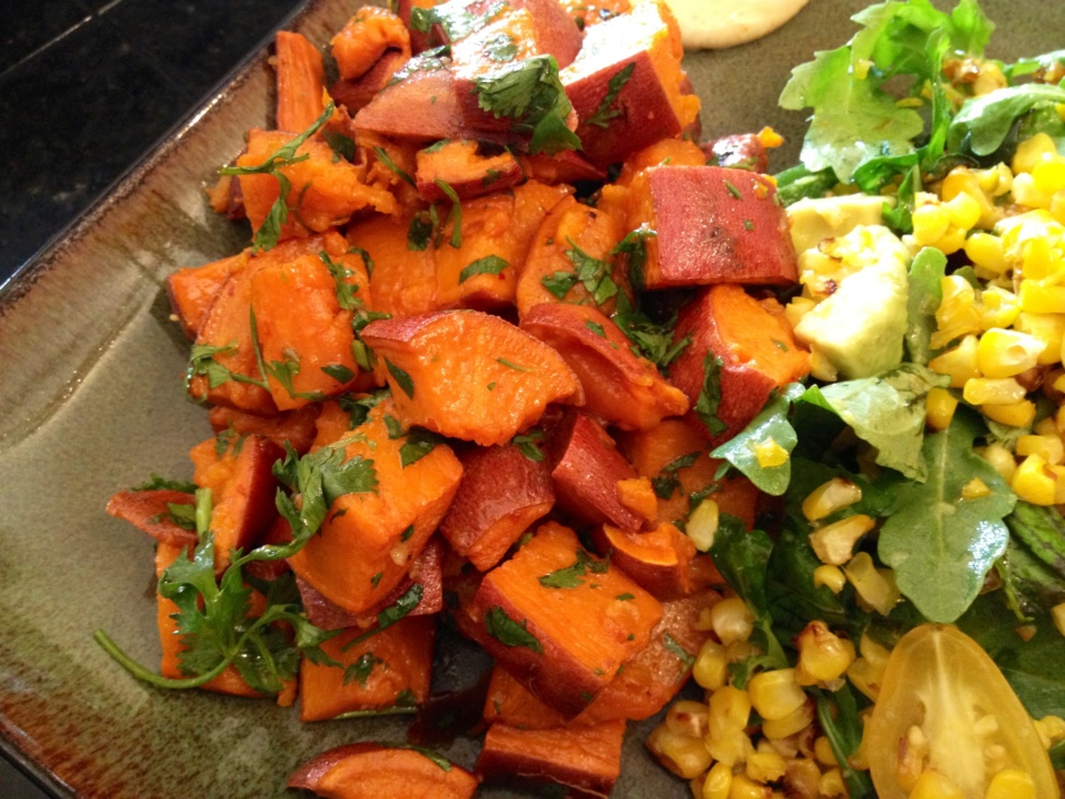 Roasted chopped sweet potatoes and a salad on a plate