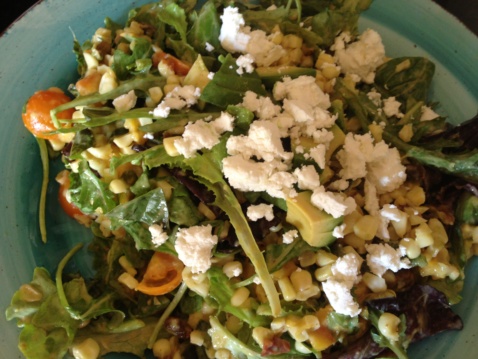 Summer salad of roasted peach, poblano and corn topped with goat cheese