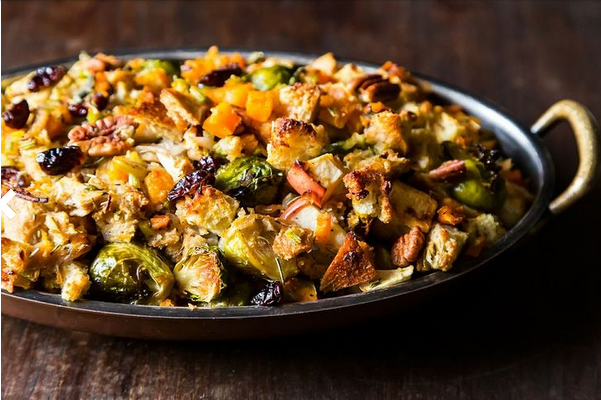 Roasted butternut squash, Brussels sprouts and bread stuffing with apples in a pan