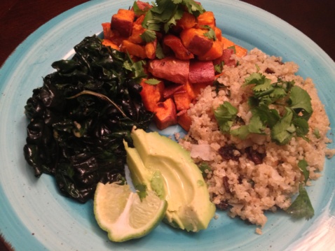 Buddha Bowl with sweet potatoes, quinoa pilaf, avocado and greens on a light blue plate