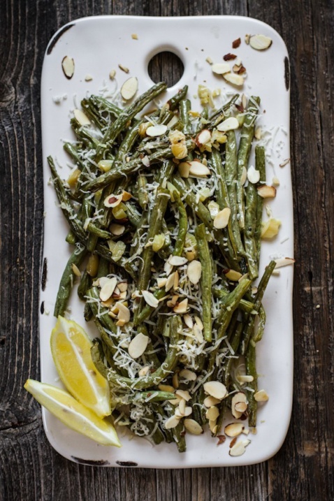 Roasted garlic green beans with lemon on a white tray