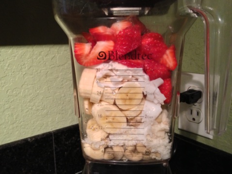 Strawberries, banana, nuts and coconut in a blender