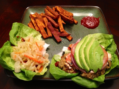 Sweet potato fries, a veggie burger and coleslaw on a plate