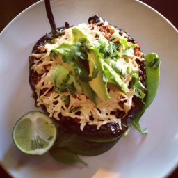 Stuffed vegan Chile Relleno topped with vegan cheese and avocado