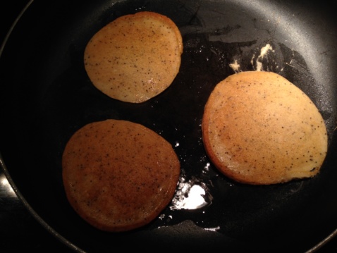 Three lemon poppy seed pancakes in a frying pan
