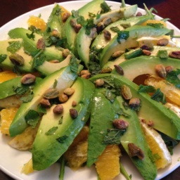 A salad of sliced avocado, oranges, and arugula