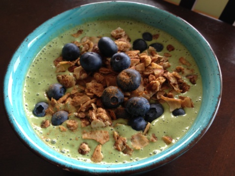 Green smoothie bowl topped with granola and blueberries