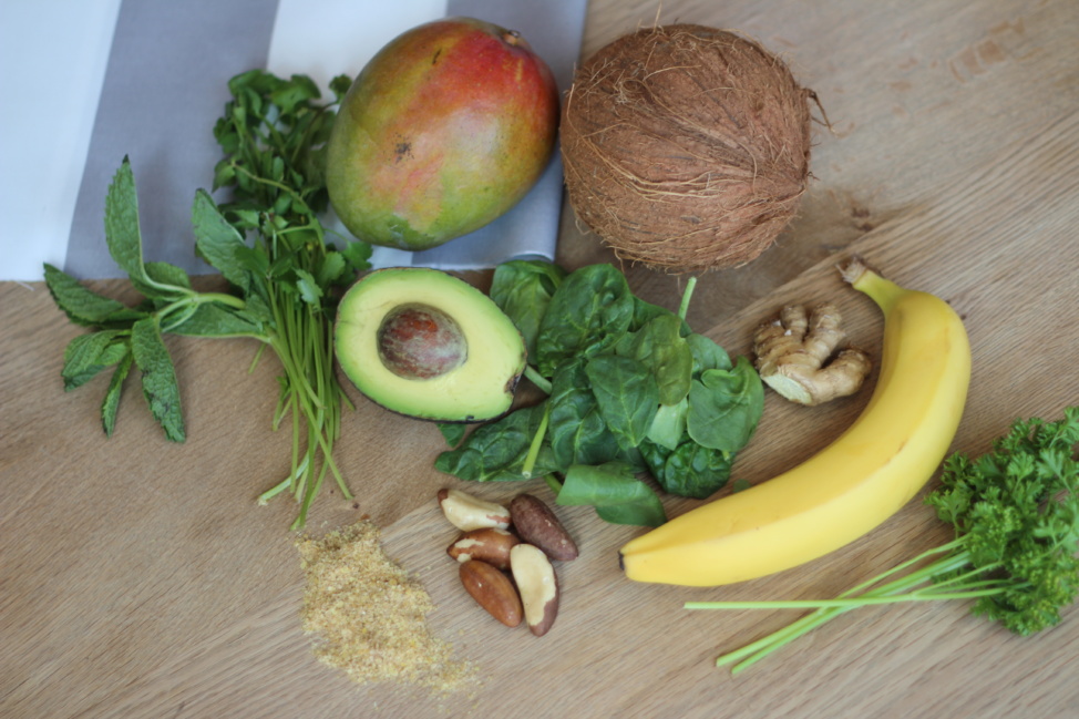 Coconut, mango, avocado, banana and greens on a table