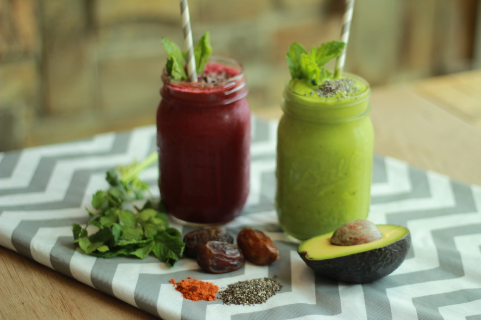 Two glasses of Jujubeet's red and a green smoothies on a kitchen towel