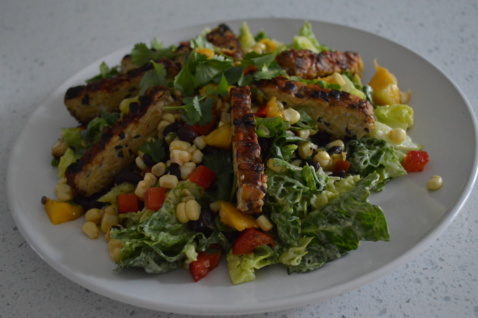 A Mexican Fiesta salad with mango black bean salsa and avocado lime dressing