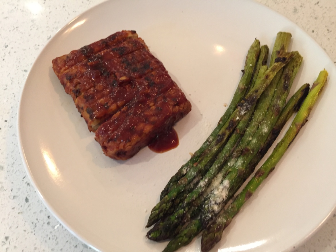 BBQ tempeh baby back ribs and grilled asparagus on a plate