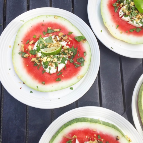 Watermelon slices topped with coconut cream and lime