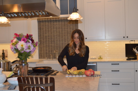 Lauren cutting a squash in her kitchen