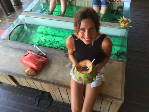 Lauren having fresh coconut water next to a fish spa tank