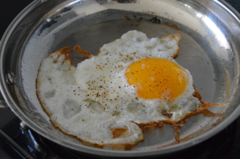A fried egg on a metal plate