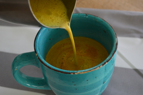 Turmeric milk being poured in a cup