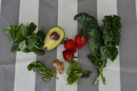 Kale, mint, avocado, strawberries, and spinach on a table