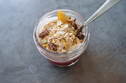 A dessert in a glass topped with oatmeal and raisins