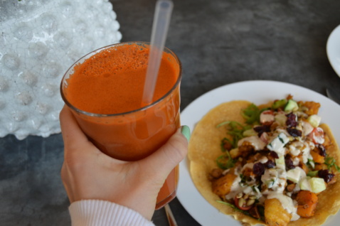 A carrot juice and a vegan taco