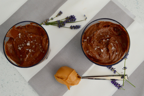 two glasses of vegan salted chocolate peanut butter mousse with coconut whipped cream