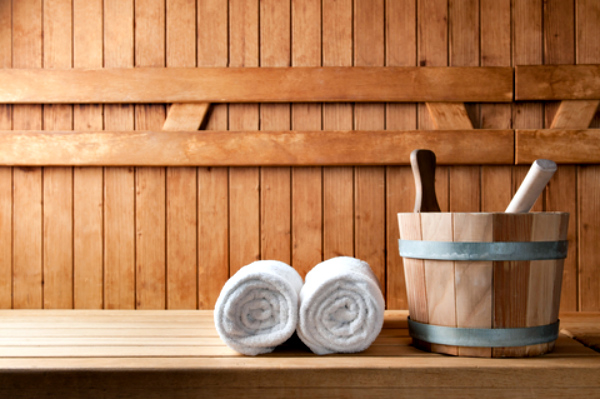 A wooden bucket and towels inside a sauna