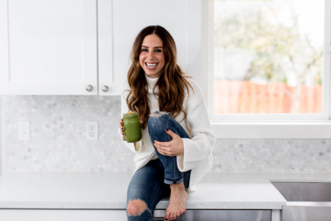 Lauren smiling and holding a green smoothie