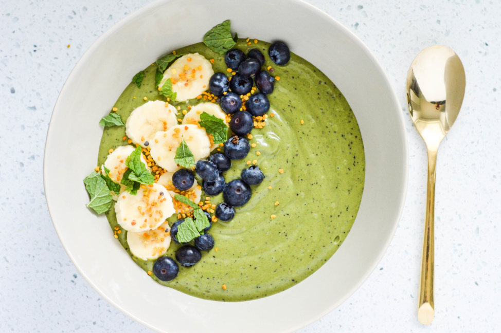 A green smoothie bowl with fruits and seeds