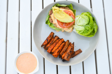 grilled turkey burgers and sweet potato fries on a porch table